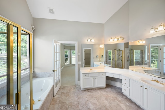 bathroom featuring tile floors, high vaulted ceiling, separate shower and tub, and vanity