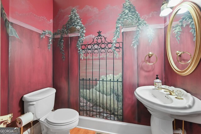 bathroom with hardwood / wood-style flooring and toilet