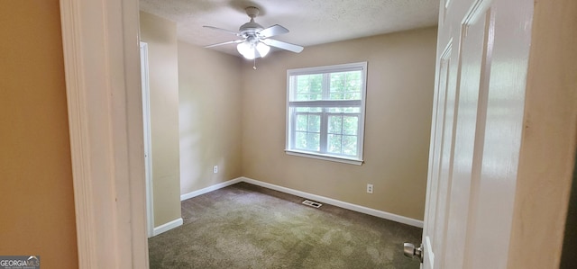 spare room featuring a textured ceiling, ceiling fan, and carpet floors