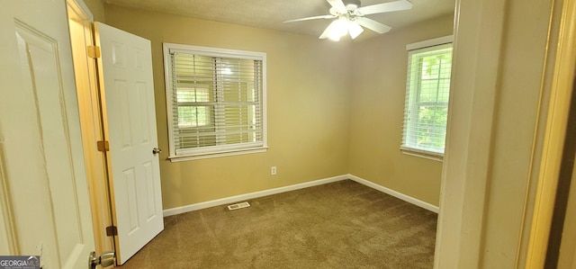 empty room with carpet floors, a textured ceiling, and ceiling fan