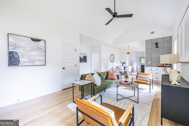 living room with high vaulted ceiling, ceiling fan, and light hardwood / wood-style flooring