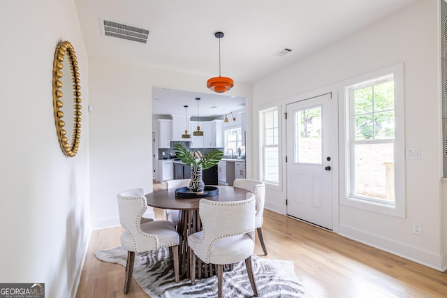 dining area with sink and light wood-type flooring