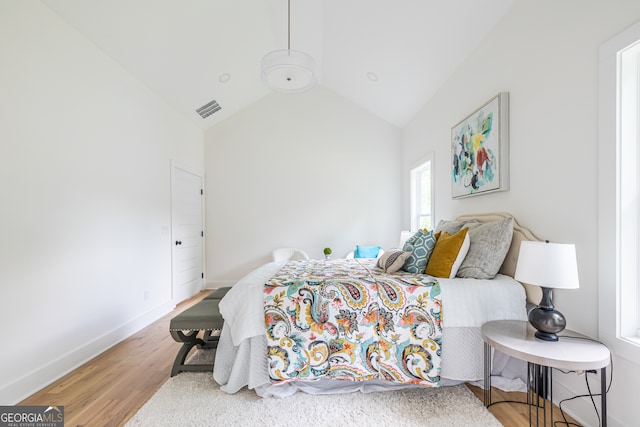 bedroom with lofted ceiling and wood-type flooring