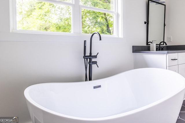 bathroom with tile flooring, plenty of natural light, and vanity