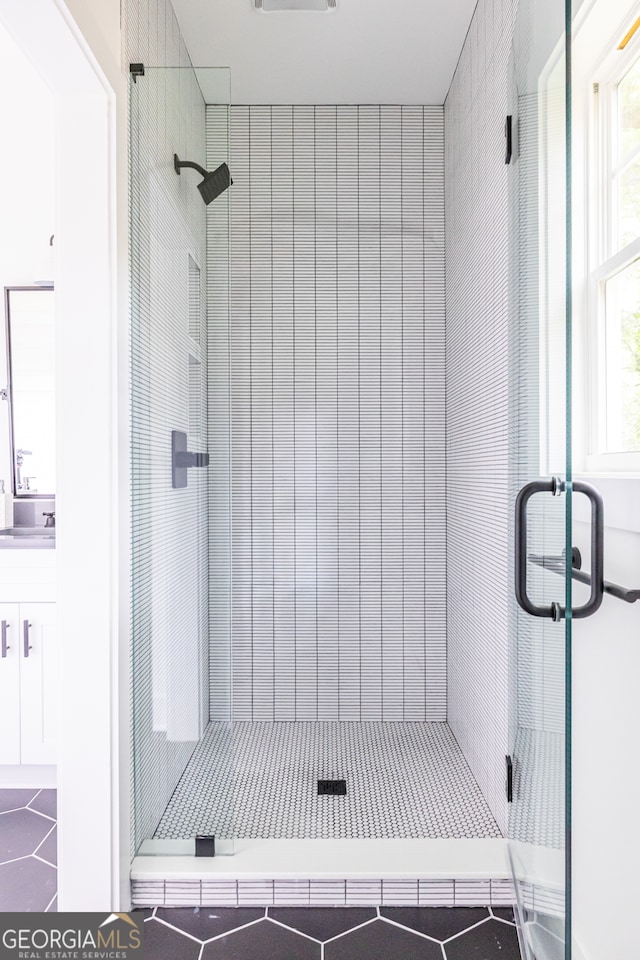 bathroom with tile floors and a shower with door