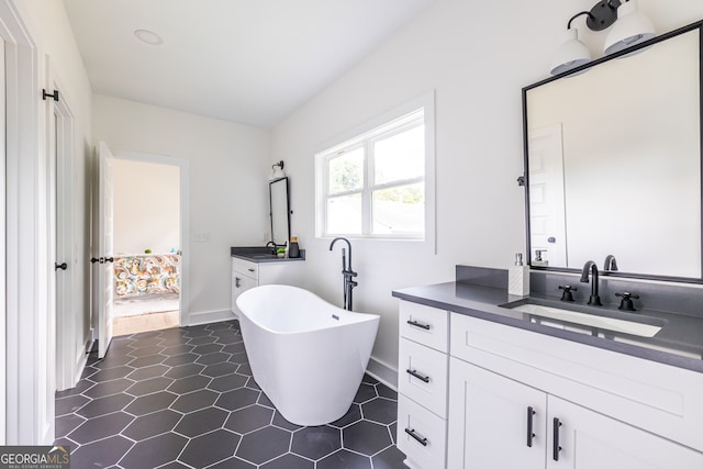 bathroom with tile floors, vanity, and a bathtub