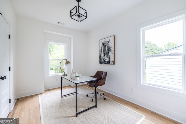 home office with light hardwood / wood-style floors and plenty of natural light