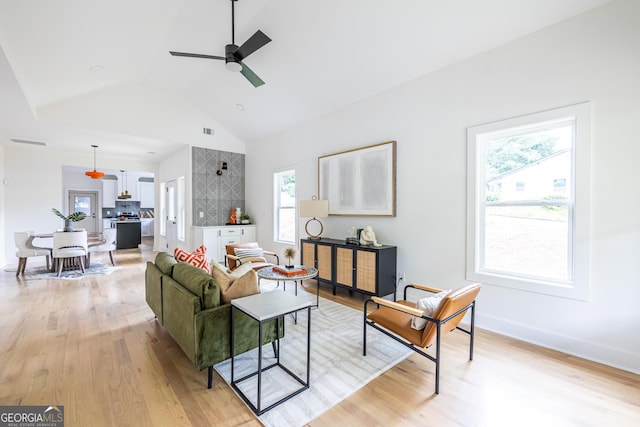 living room featuring ceiling fan, a healthy amount of sunlight, light hardwood / wood-style floors, and high vaulted ceiling