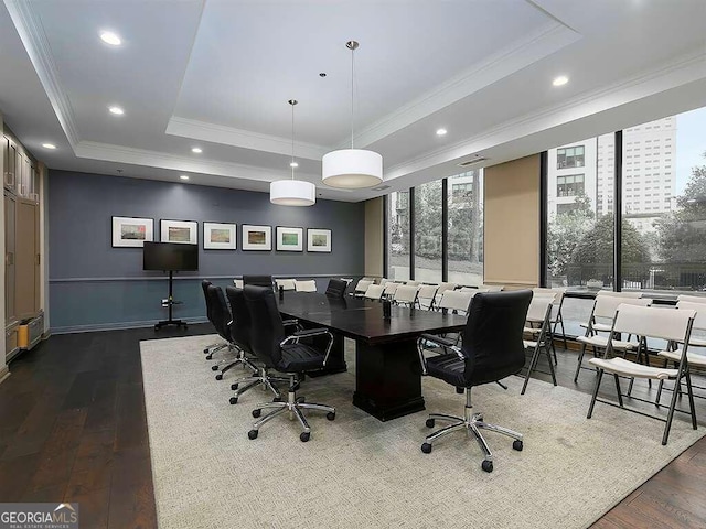 office with ornamental molding, dark wood-type flooring, and a raised ceiling