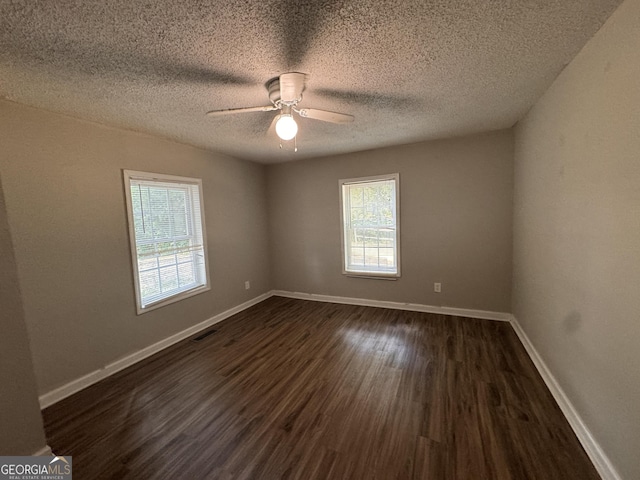 unfurnished room featuring ceiling fan, dark wood-type flooring, and a textured ceiling