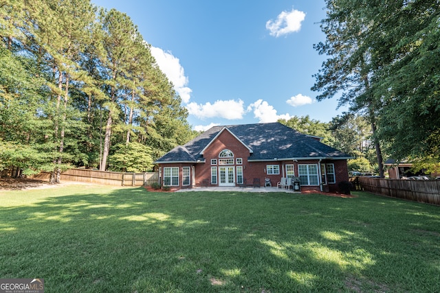 back of house with french doors and a yard