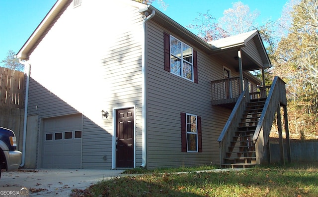 view of side of home featuring a garage and a wooden deck