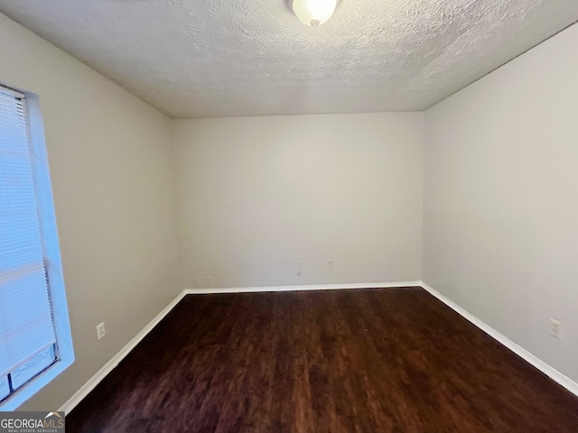 unfurnished room with hardwood / wood-style floors and a textured ceiling