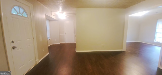 spare room with a textured ceiling and dark hardwood / wood-style floors