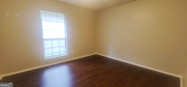 spare room featuring a textured ceiling and dark wood-type flooring