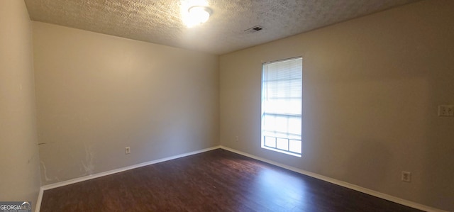 foyer featuring dark hardwood / wood-style flooring, a textured ceiling, and a wealth of natural light