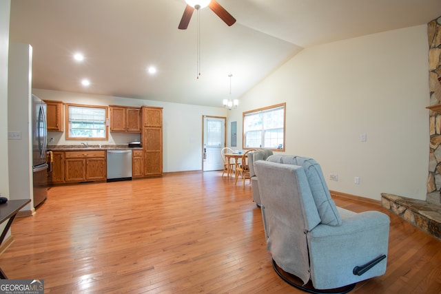 living room featuring a healthy amount of sunlight, light wood-type flooring, and ceiling fan with notable chandelier