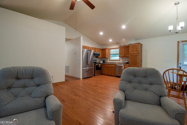 living room featuring high vaulted ceiling, light hardwood / wood-style flooring, and ceiling fan with notable chandelier