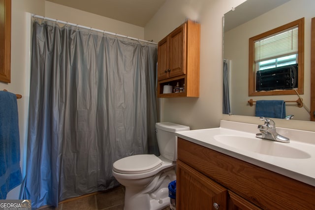 bathroom with tile floors, oversized vanity, and toilet