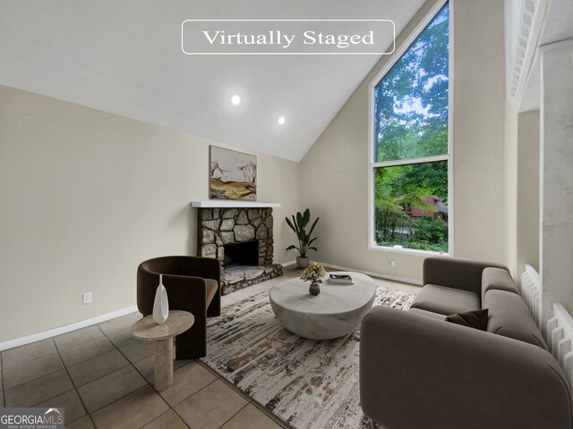 tiled living room featuring vaulted ceiling and a stone fireplace