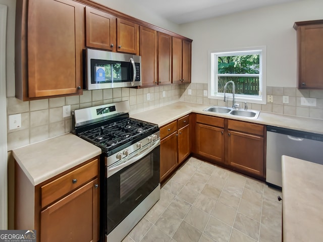 kitchen featuring tasteful backsplash, sink, light tile patterned flooring, and stainless steel appliances