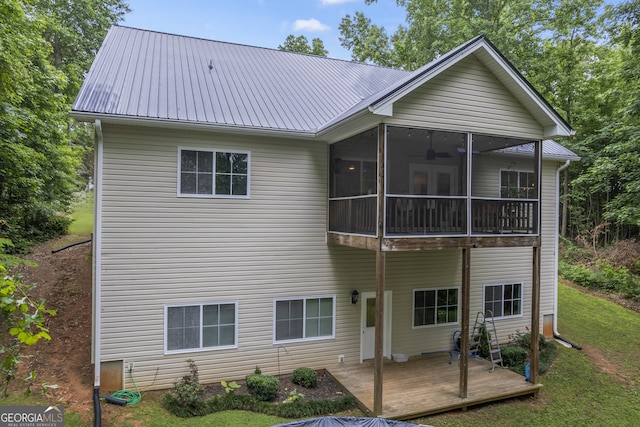 rear view of house featuring a sunroom and a lawn