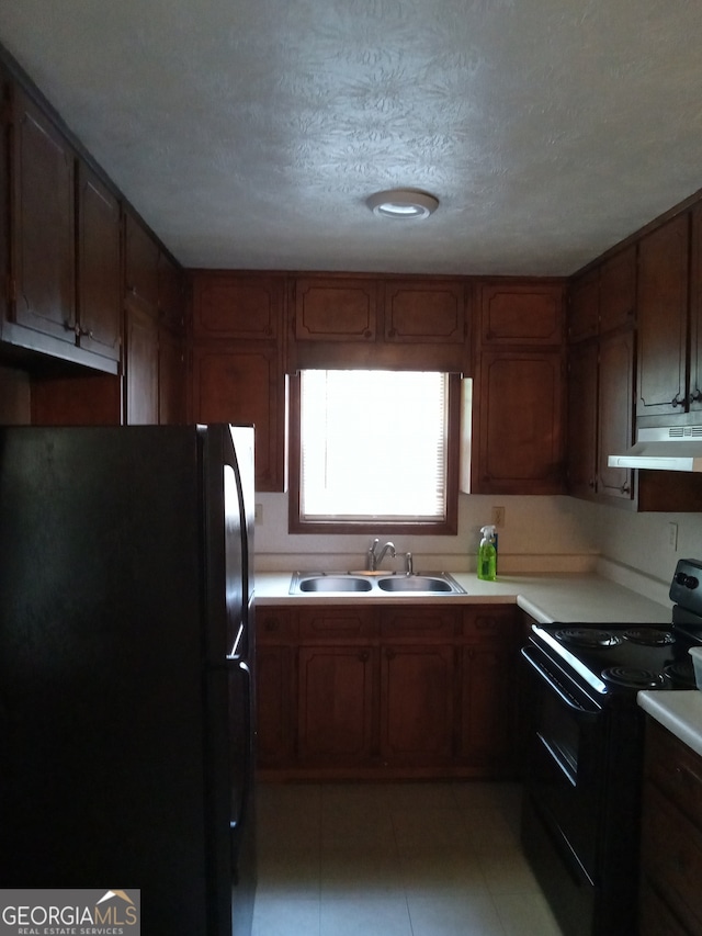 kitchen featuring black appliances, sink, light tile flooring, and a textured ceiling