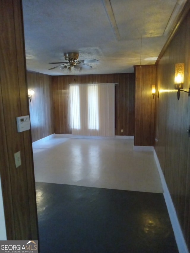 spare room with wooden walls and ceiling fan