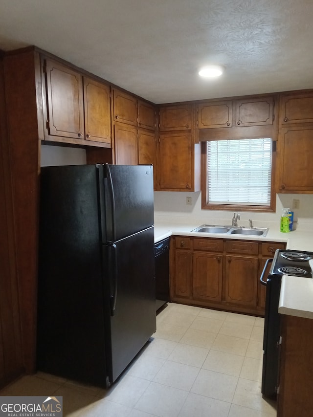 kitchen with black appliances, sink, and light tile floors