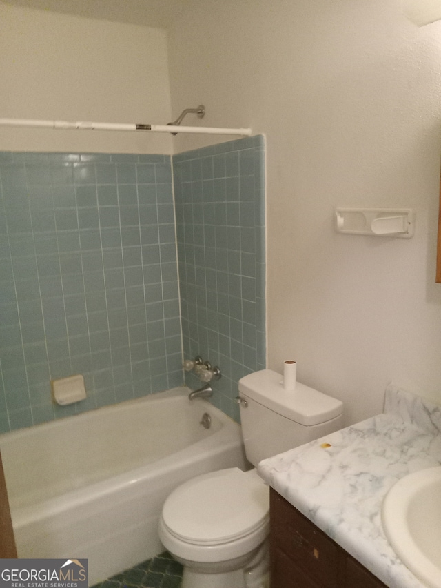 full bathroom featuring tile floors, vanity, toilet, and tiled shower / bath combo