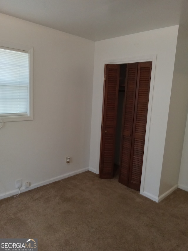 unfurnished bedroom featuring carpet and a closet