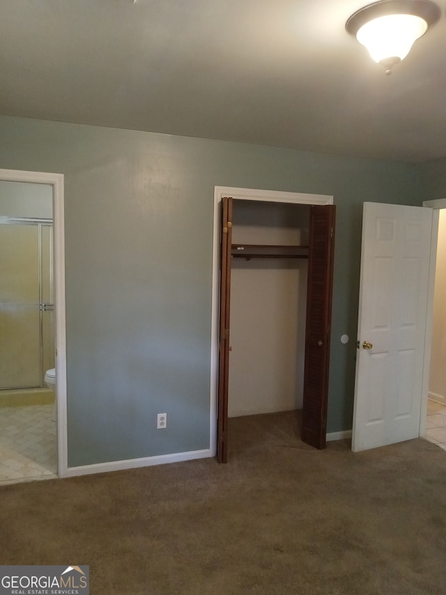 unfurnished bedroom with carpet and connected bathroom