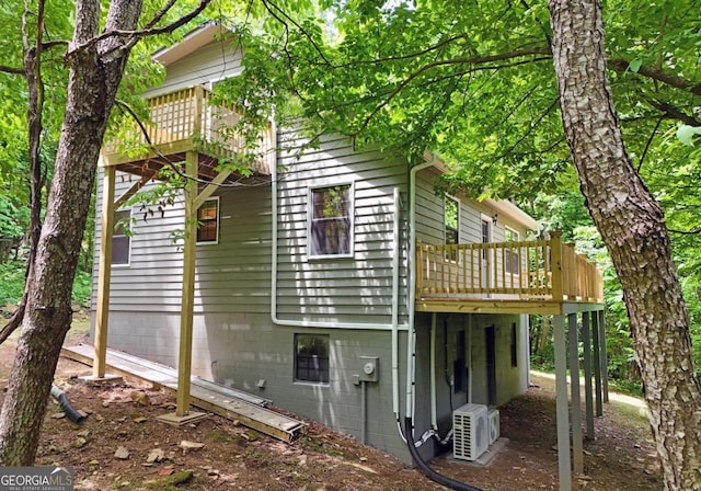 back of house featuring a deck and central AC unit