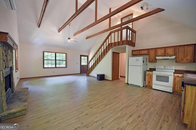 kitchen featuring a stone fireplace, white appliances, and wood-type flooring