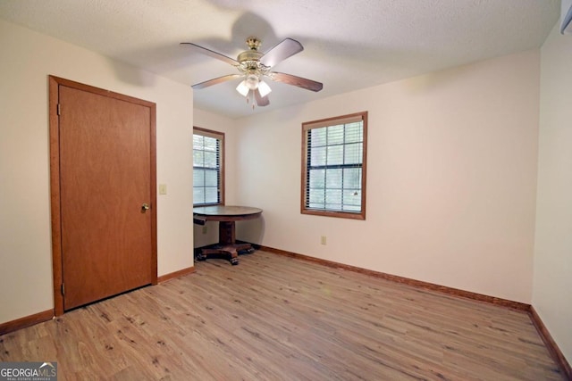 unfurnished bedroom featuring ceiling fan, light hardwood / wood-style floors, and a textured ceiling