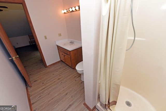 bathroom featuring a shower with shower curtain, hardwood / wood-style floors, toilet, and vanity