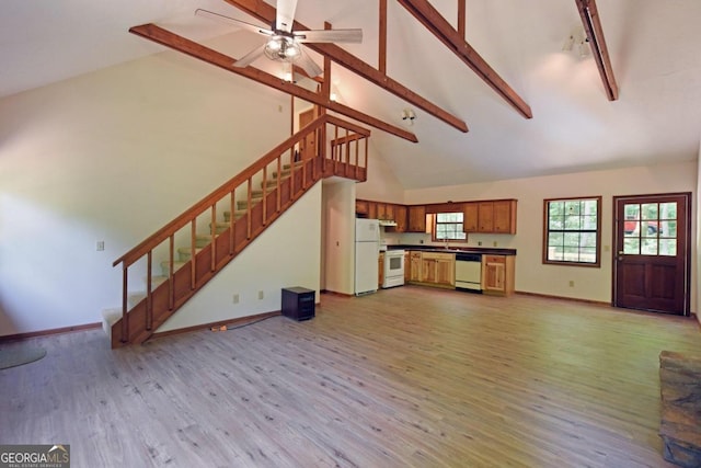 unfurnished living room with hardwood / wood-style flooring, beam ceiling, high vaulted ceiling, sink, and ceiling fan