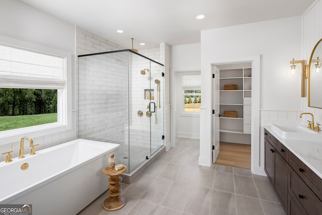 bathroom with tile flooring, independent shower and bath, and vanity