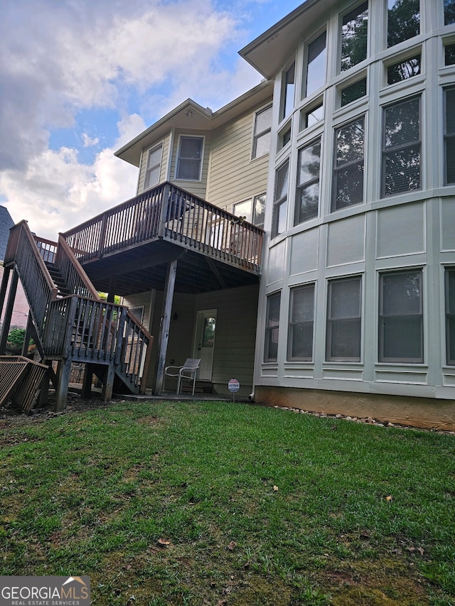 back of house with stairway, a yard, and a deck