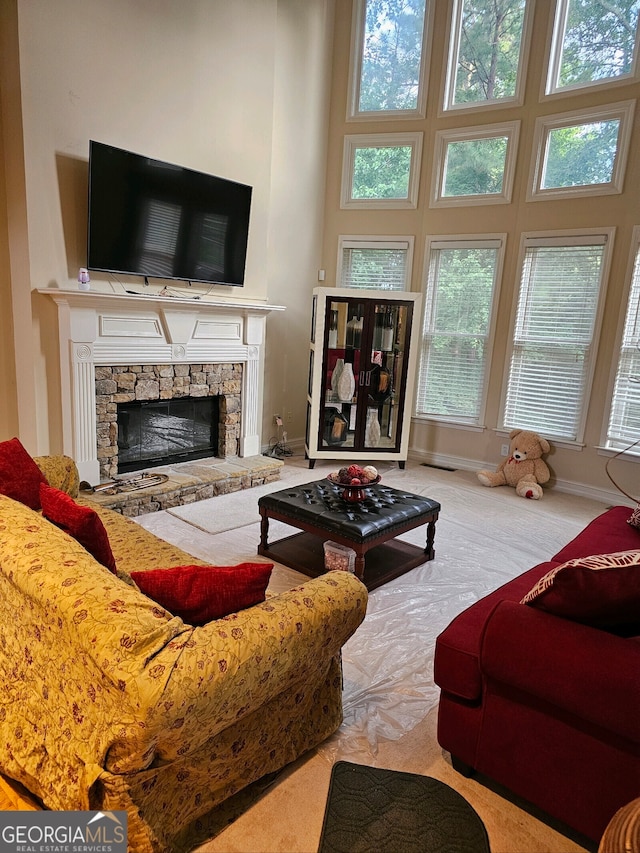 living room with a fireplace, a high ceiling, and light carpet