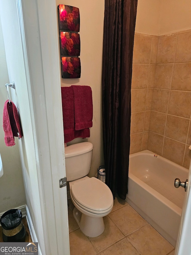 bathroom featuring shower / tub combo, tile patterned floors, and toilet