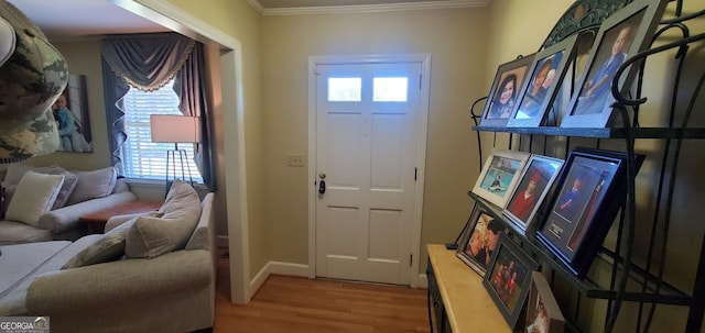 foyer entrance featuring a wealth of natural light, ornamental molding, and wood-type flooring