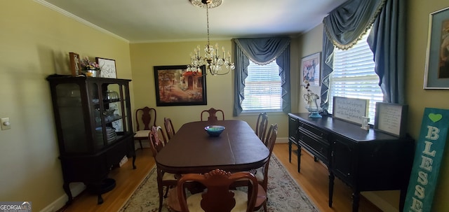 dining space featuring a notable chandelier, crown molding, and wood-type flooring