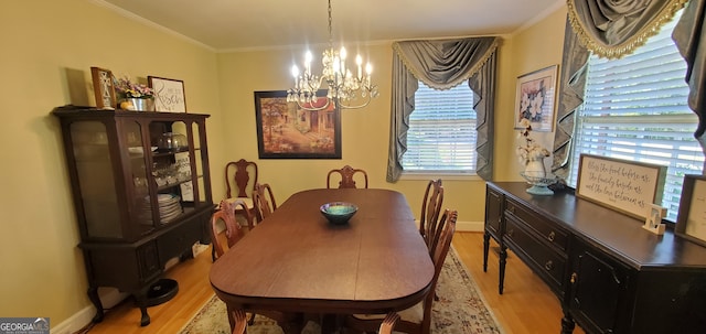 dining space with a wealth of natural light, a notable chandelier, ornamental molding, and light hardwood / wood-style flooring