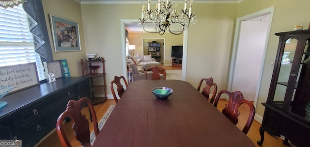 dining area featuring hardwood / wood-style floors, a chandelier, and crown molding