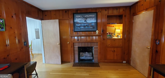 living room with light hardwood / wood-style floors and wood walls