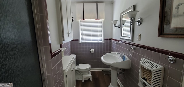 bathroom with backsplash, hardwood / wood-style flooring, toilet, and tile walls