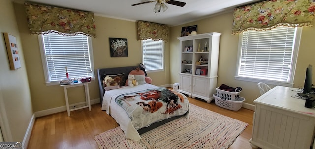 bedroom with light hardwood / wood-style floors, ceiling fan, and multiple windows