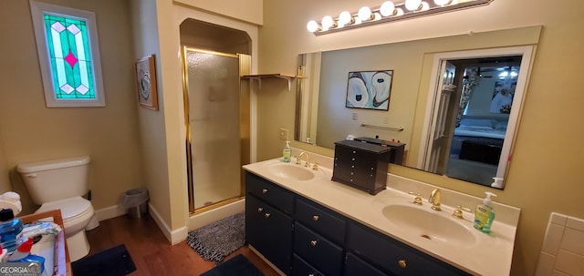 bathroom with toilet, hardwood / wood-style floors, large vanity, walk in shower, and double sink