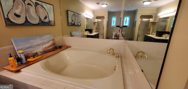 bathroom with tiled tub, crown molding, and large vanity